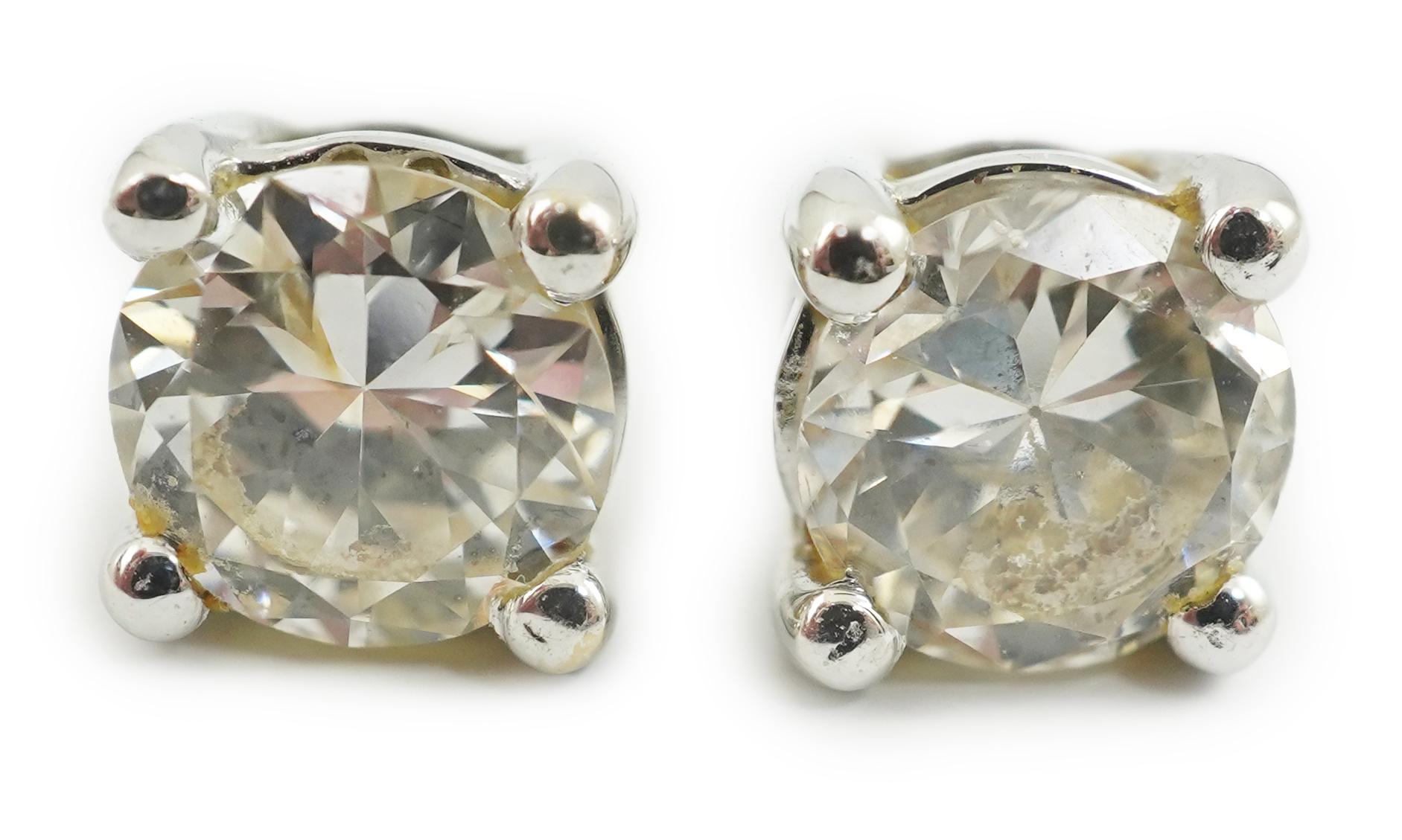 A modern pair of 18k white gold and solitaire diamond set ear studs